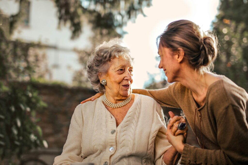 Madre adulta conversando con su madre mayor en el jardín