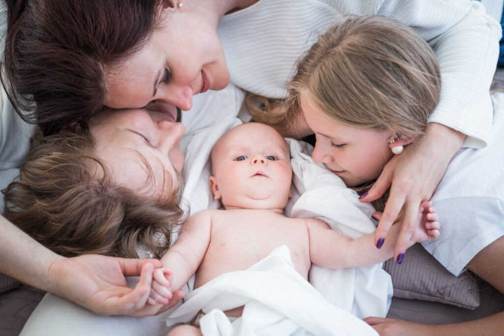 Madre acostada abrazando a sus hijos pequeños